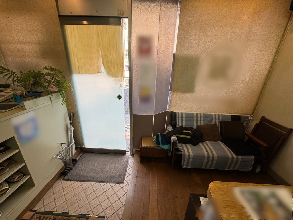 貼替前の理容室の入口まわり。古い窓フィルムと店内の様子